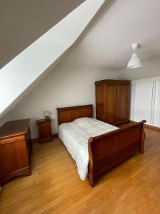 sypialnia z łóżkiem i 2 komodami na poddaszu w obiekcie Charmante maison en pierre w mieście Morlaix