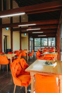 a dining room with tables and orange chairs at Paradise Point in Vartop