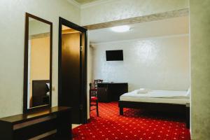 - une chambre avec un lit, un miroir et un tapis rouge dans l'établissement Paradise Point, à Vartop