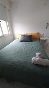 een bed met een groen dekbed in een kamer bij Departamento Céntrico Chaco in Resistencia