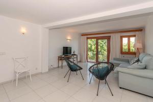 a living room with a couch and chairs and a tv at Vora Mar Beachfront Apartment by Sealand Villas in Port de Pollensa