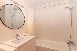 a bathroom with a sink and a tub and a mirror at Vora Mar Beachfront Apartment by Sealand Villas in Port de Pollensa +23 photos