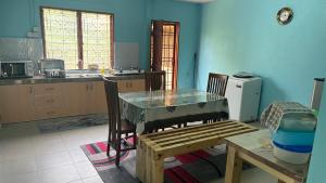 昔加末的住宿－Segamat Tunas Homestay，厨房配有桌子和长凳