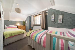 a bedroom with two beds and a wall at The Shippen at Fowey in Fowey