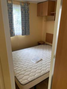 a small bedroom with a bed in it at Mobil-Home standard in Voyennes