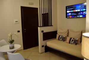 een woonkamer met een bank en een tv aan de muur bij Holiday a San Pietro in Rome