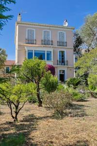 une grande maison avec des arbres devant elle dans l'établissement Maison de Maître Centre Ville, à Hyères