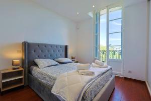 - une chambre avec un grand lit et une grande fenêtre dans l'établissement Maison de Maître Centre Ville, à Hyères