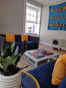 a living room with a blue couch and a table at The Mews Cottage in Penzance