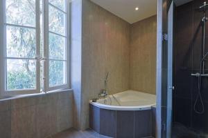 baño con bañera y ducha con ventana en Maison de Maître Centre Ville, en Hyères