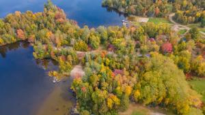 an aerial view of a river and trees with autumn foliage at Lakepoint Cottage Resort in Killaloe Station