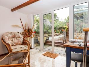 a living room with a table and a chair at Hazeldene Stables in Exeter