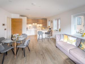 een woonkamer en een keuken met een bank en een tafel bij Pass the Keys Contemporary Apartment with Secure Parking in Shrewsbury