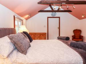 a bedroom with a large bed and a chair at Hazeldene Stables in Exeter