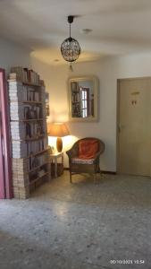 a living room with a chair and a mirror at LA MAISON DU BONHEUR in Velleron