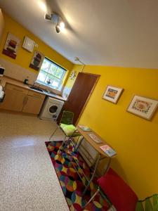 a kitchen with yellow walls and a table in a room at Old Dairy in Tain