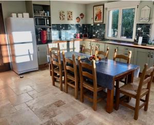 eine Küche mit einem Tisch und Stühlen sowie einem Kühlschrank in der Unterkunft La Tourouzelle in Lauraguel