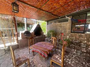 patio con mesa, sillas y pared de ladrillo en CABAÑAS TIA FLOR, en Pica