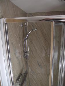 a shower with a glass door in a bathroom at 6B Church St. Dingwall Apartment in Dingwall