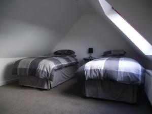 two beds in a attic room with a sloping ceiling at 6B Church St. Dingwall Apartment in Dingwall