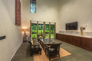 a living room with a table and some chairs at SaffronStays Amavi Beach House in Dapoli