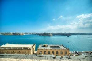 a large building in the middle of a body of water at 1bedroom-stunning views in Valletta center JSPI1-1 in Valletta