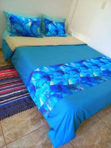 edredón azul y almohadas en la cama en HOTEL TRAVEL Encarnación, en Encarnación