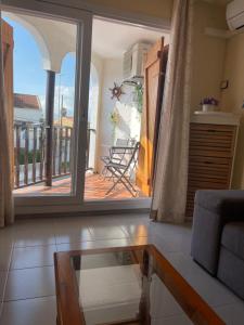 a living room with a glass table and a balcony at Las tres palmeras in Vinarós