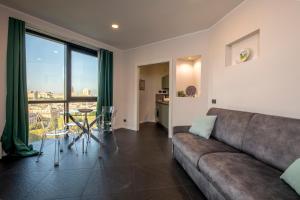 uma sala de estar com um sofá e uma mesa em 225 - La Corte Luxury Apartment, Centro città con vista panoramica e PARCHEGGIO PRIVATO GRATUITO INCLUSO em Génova