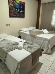 two beds in a hospital room with towels on them at HOTEL TURISMO MT in Chapada dos Guimarães