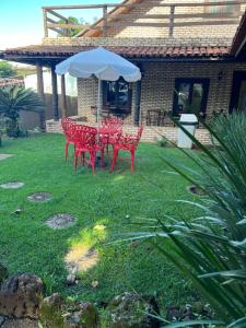 einen Tisch und Stühle unter einem Regenschirm im Hof in der Unterkunft HOTEL TURISMO MT in Chapada dos Guimarães