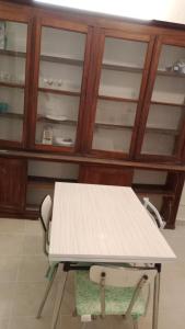 a table and a chair in a room with wooden cabinets at L'ombrelle in Carcassonne