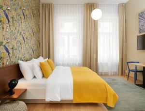 a bedroom with a bed with a yellow blanket at City Nest Apartments by Adrez in Prague