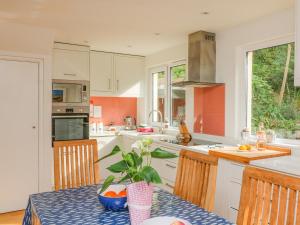 a kitchen with white cabinets and a table with a plant at 3 Bonaventure Close in Salcombe