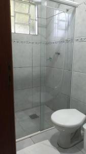 ein Bad mit einer Glasdusche und einem WC in der Unterkunft HOTEL TURISMO MT in Chapada dos Guimarães