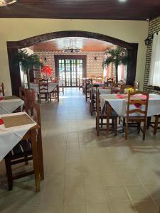 HOTEL TURISMO MT في شابادا دوس غيماريش: غرفة طعام مع طاولات وكراسي في مطعم