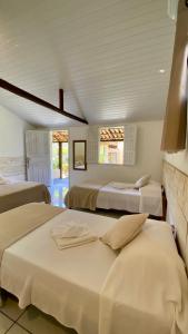 um quarto com 3 camas e 2 janelas em Pousada Amora Caraiva em Caraíva mais 45 fotografias