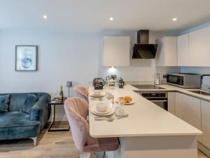 シュルーズベリーにあるPass the Keys Amaranth Stylish town centre apartmentのテーブルと椅子のあるキッチンとリビングルーム