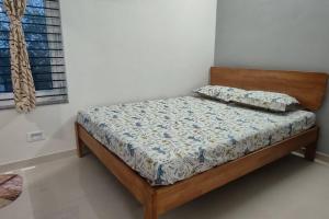a bed in a room with a white wall at Compact yet beautiful 1bhk 305 in Bangalore +9 photos