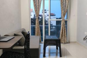 a living room with a table and a couch and a window at Compact yet beautiful 1bhk 305 in Bangalore