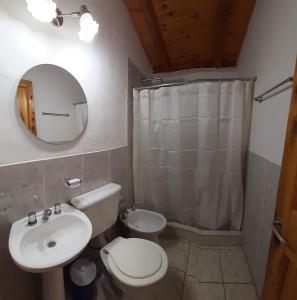 y baño con lavabo, aseo y espejo. en Cabañas Samay en Casa Grande