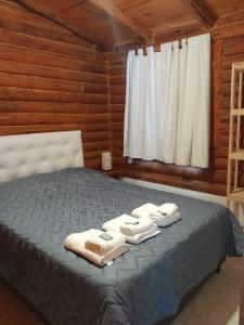 a bed in a log cabin with towels on it at Cabañas Samay in Casa Grande