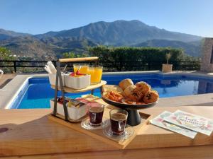 een dienblad met eten op een tafel naast een zwembad bij Casita Johanna in Viñuela