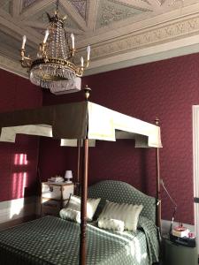 盧卡的住宿－Camera in centro storico Lucca，一间卧室配有一张天蓬床和吊灯。