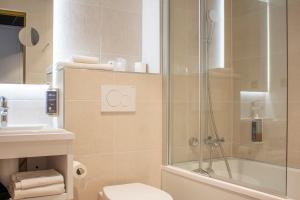 La salle de bains est pourvue d'une douche, de toilettes et d'un lavabo. dans l'établissement Brit Hotel Bordeaux Aéroport - Le Soretel, à Mérignac