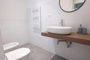 La salle de bains blanche est pourvue d'un lavabo et d'un miroir. dans l'établissement [700mStazioneCentrale]Ampio Trilocale con 2Balconi, à Trieste