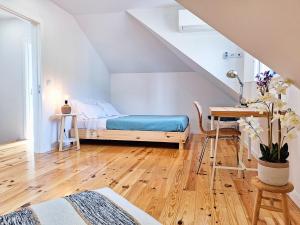 a bedroom with a bed and a desk and a table at Tílias House in Covilhã