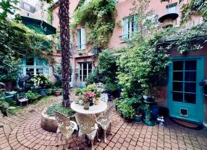 a patio with a table and chairs in front of a building at "Maison 1850 Paris 18" Chambre avec terrasse et parking en option in Paris