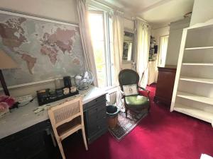 a room with a desk with a map on the wall at "Maison 1850 Paris 18" Chambre avec terrasse et parking en option in Paris