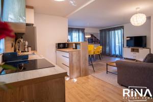 a kitchen and living room with a couch and a table at Kuća za odmor Rina in Pakrac